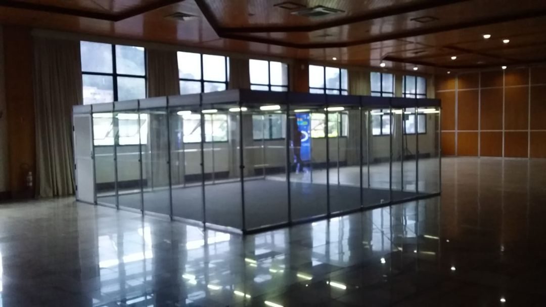 Sala fechada em vidro temperado com iluminação em evento