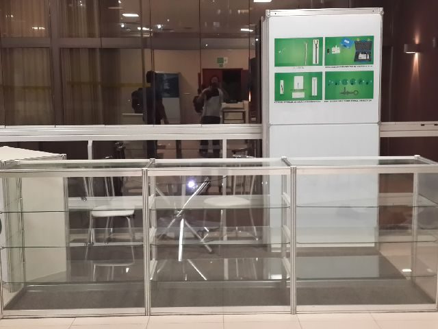 Balcão em vidro com três prateleiras e porta de correr em stand