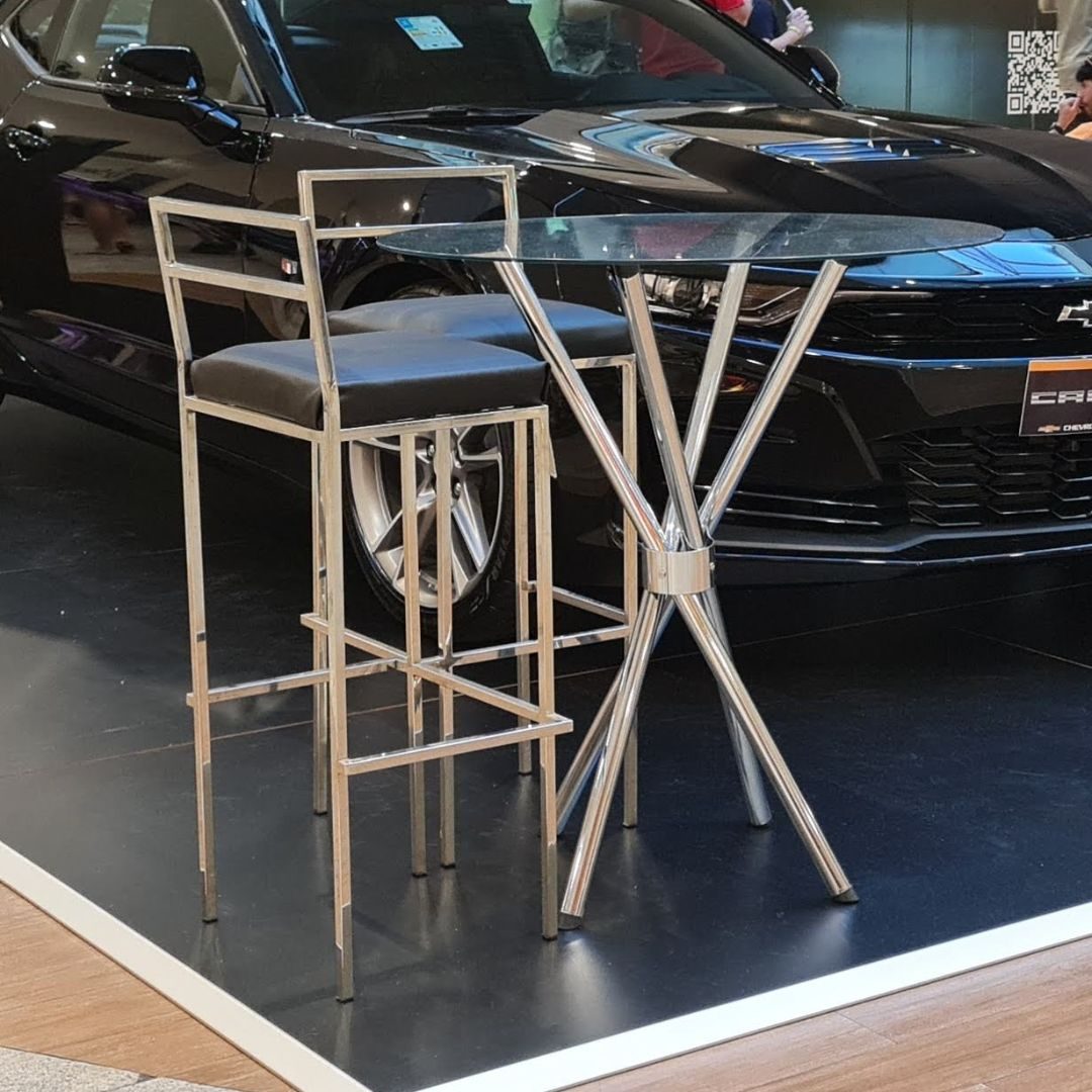 Mesa bistrô cromada com tampo de vidro e banquetas em inox