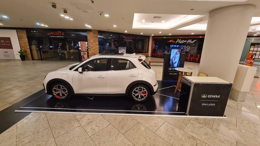 Tablado com piso adesivado e carro em exposição